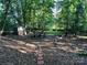 The backyard is spacious with a shed, fire pit, and a hammock surrounded by lush greenery at 8217 Lansford Rd, Charlotte, NC 28277
