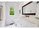Elegant bathroom with white vanity, black faucet, and natural light from the window at 8217 Lansford Rd, Charlotte, NC 28277