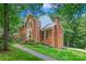 Charming brick home with well-manicured landscaping, complemented by a welcoming front porch and a paved walkway at 8217 Lansford Rd, Charlotte, NC 28277