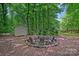 Relax in a serene, wooded setting at this fire pit, complete with rustic log seating and a storage shed at 8217 Lansford Rd, Charlotte, NC 28277