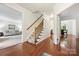 Open hallway with hardwood floors, staircase, and views into the living and dining rooms at 8217 Lansford Rd, Charlotte, NC 28277