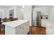 Open-concept kitchen featuring white cabinetry, stainless steel refrigerator, and a breakfast bar at 8217 Lansford Rd, Charlotte, NC 28277
