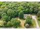 Aerial view shows property surrounded by mature trees, long driveway, and lush lawn at 8622 Lower Rocky River Rd, Concord, NC 28025