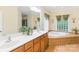 Bathroom featuring a jetted tub, dual sinks, wood cabinets, and tiled floors at 8622 Lower Rocky River Rd, Concord, NC 28025