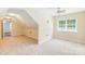 Large, neutral bonus room features neutral carpet, a ceiling fan and natural light at 8622 Lower Rocky River Rd, Concord, NC 28025