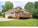 Exterior elevation showcasing the deck, garage, driveway, and green lawn of the home at 8622 Lower Rocky River Rd, Concord, NC 28025