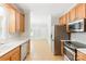 Well-lit kitchen featuring wood cabinets, stainless steel appliances, and tile flooring throughout at 8622 Lower Rocky River Rd, Concord, NC 28025