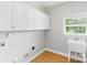 Functional laundry room with white cabinets, a sink, and tile flooring at 8622 Lower Rocky River Rd, Concord, NC 28025