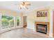 Comfortable living room featuring a fireplace, a ceiling fan, and large windows at 8622 Lower Rocky River Rd, Concord, NC 28025