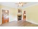 Cozy living room with a fireplace, ceiling fan, and wood-look flooring at 8622 Lower Rocky River Rd, Concord, NC 28025