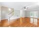 Spacious living room with gleaming hardwood floors, staircase, and ample natural light at 8622 Lower Rocky River Rd, Concord, NC 28025