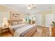 Beautiful bedroom with wood look floors, natural light, and a view into the ensuite bathroom at 8622 Lower Rocky River Rd, Concord, NC 28025