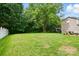 Spacious backyard featuring lush green grass and mature trees providing ample shade at 9856 Caldwell Depot Rd, Cornelius, NC 28031