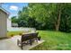 Large backyard has a stone patio area with chairs and a lush lawn at 9856 Caldwell Depot Rd, Cornelius, NC 28031