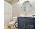 Cozy bathroom features a modern vanity with a marble countertop and round mirror at 9856 Caldwell Depot Rd, Cornelius, NC 28031