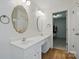 Bathroom featuring double sinks, decorative mirrors, and wood-look floors at 9856 Caldwell Depot Rd, Cornelius, NC 28031