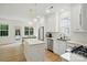 Modern kitchen with white cabinets, an island, and stainless steel appliances overlooking dining at 9856 Caldwell Depot Rd, Cornelius, NC 28031