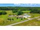 Picturesque aerial view of a brick home with a pond, an outbuilding, and lush greenery at 9950 Foil Rd, Mount Pleasant, NC 28124