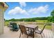 Enjoy this back deck with an outdoor dining set overlooking a scenic yard with distant views and blue skies at 9950 Foil Rd, Mount Pleasant, NC 28124