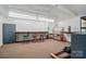 Finished basement featuring built-in work areas, white wainscoting, and fluorescent lighting at 9950 Foil Rd, Mount Pleasant, NC 28124