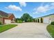 Long driveway leading to a brick home with an attached garage and a large outbuilding with a big garage door at 9950 Foil Rd, Mount Pleasant, NC 28124