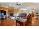 Cozy living room with a stone fireplace, hardwood floors, leather furniture, and views into the kitchen at 9950 Foil Rd, Mount Pleasant, NC 28124