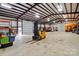 This outbuilding features a tall ceiling, yellow forklift, and ample space for all your project needs at 9950 Foil Rd, Mount Pleasant, NC 28124