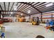 This outbuilding features a tall ceiling, yellow forklift, and ample storage space for all your equipment and tools at 9950 Foil Rd, Mount Pleasant, NC 28124
