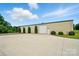 A large outbuilding is featured, with a big garage door and a row of bushes lining the gravel area at 9950 Foil Rd, Mount Pleasant, NC 28124