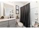 Bathroom featuring a dark shower curtain, gray cabinets, and decor for a modern and clean feel at 10045 Carousel Corral Dr, Midland, NC 28107