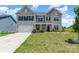 Charming two-story home boasts a manicured lawn, inviting entrance, and a two-car garage at 10045 Carousel Corral Dr, Midland, NC 28107