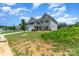 Charming two-story home boasts a manicured lawn, inviting entrance, and a two-car garage at 10045 Carousel Corral Dr, Midland, NC 28107