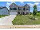 Charming two-story home boasts a manicured lawn, inviting entrance, and a two-car garage at 10045 Carousel Corral Dr, Midland, NC 28107