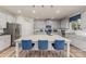 A bright kitchen features gray cabinets, stainless steel appliances, and a large island with blue seating at 10045 Carousel Corral Dr, Midland, NC 28107