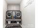 Efficient laundry room with gray cabinets, a folding area, and a decorative laundry-themed wall decal at 10045 Carousel Corral Dr, Midland, NC 28107