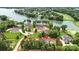 Wide aerial view of a lakeside property featuring an elegant home surrounded by mature trees and lush landscaping at 106 Kent Ct, Mooresville, NC 28117