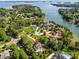 Aerial view of an estate home with pool and lake views surrounded by mature trees and lush landscaping at 106 Kent Ct, Mooresville, NC 28117