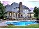 Beautiful backyard with a luxurious pool and a stone patio, perfect for entertaining and relaxation with a beautiful home at 106 Kent Ct, Mooresville, NC 28117