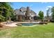 Stunning backyard showcasing a pool, spa, stone fireplace, and lush greenery at 106 Kent Ct, Mooresville, NC 28117