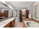 Luxurious bathroom with a soaking tub, double vanity, and dark wood cabinets at 106 Kent Ct, Mooresville, NC 28117