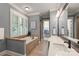 Bright bathroom with tiled floor, double vanity, soaking tub, plantation shutters, and walk-in closet at 106 Kent Ct, Mooresville, NC 28117