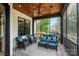 Comfortable screened-in porch with wicker furniture, ceiling fan, and views of the landscaped backyard at 106 Kent Ct, Mooresville, NC 28117
