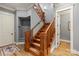 Inviting staircase with wooden railing and trim, complemented by wood flooring and natural light at 106 Kent Ct, Mooresville, NC 28117
