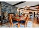 Cozy dining area with a stone fireplace, wooden beams, and a round table for Gathering gatherings at 111 Gordon Ave, Shelby, NC 28152