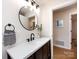 Bathroom features a modern vanity with a round mirror, stylish fixtures and a decorative hand towel at 1152 Penrose Ln, Charlotte, NC 28217