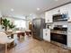 Open concept kitchen with stainless steel appliances and view to dining and living area at 1152 Penrose Ln, Charlotte, NC 28217