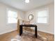 This bright office has a dark desk, wicker chair, bright windows, and wood-look floors at 1152 Penrose Ln, Charlotte, NC 28217