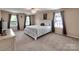 This bedroom has neutral walls and carpet with a large bed, windows, and a ceiling fan at 121 Royalton Rd, Mooresville, NC 28115