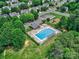 Aerial shot of a community pool, clubhouse, playground, and parking amidst verdant trees and manicured lawns at 121 Royalton Rd, Mooresville, NC 28115