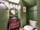 Stylish powder room with dark green walls, a decorative mirror, and a modern vanity at 121 Royalton Rd, Mooresville, NC 28115